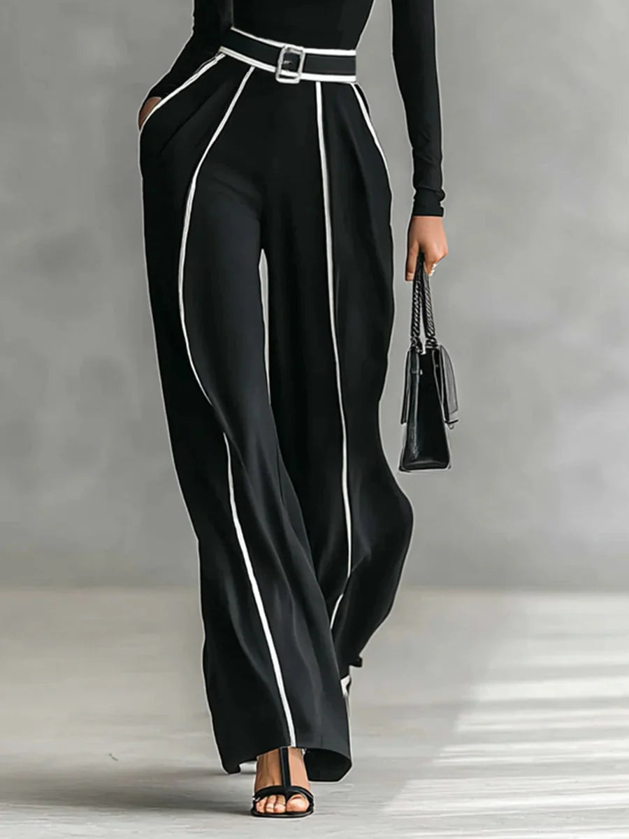 Conjunto de top blanco de cuello alto y manga larga con pantalones de pierna ancha y cinturón.