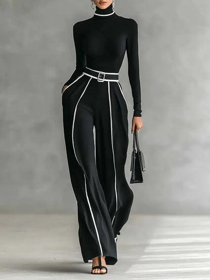 Conjunto de top blanco de cuello alto y manga larga con pantalones de pierna ancha y cinturón.