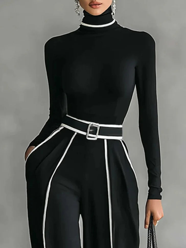 Conjunto de top blanco de cuello alto y manga larga con pantalones de pierna ancha y cinturón.