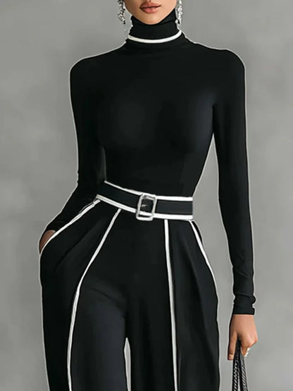 Conjunto de top blanco de cuello alto y manga larga con pantalones de pierna ancha y cinturón.